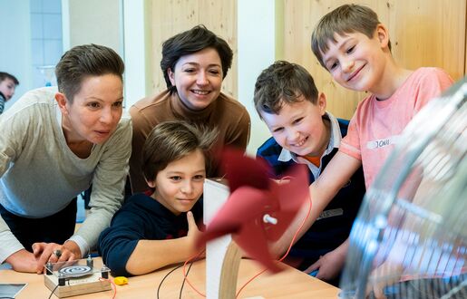 Zwei Lünestrom-Mitarbeiterinnen und drei Schüler an der Windenergie-Station des mobilen Energielabors vom SCHUBZ in Kooperation mit Lünestrom.