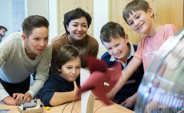 Zwei Lünestrom-Mitarbeiterinnen und drei Schüler an der Windenergie-Station des mobilen Energielabors vom SCHUBZ in Kooperation mit Lünestrom.