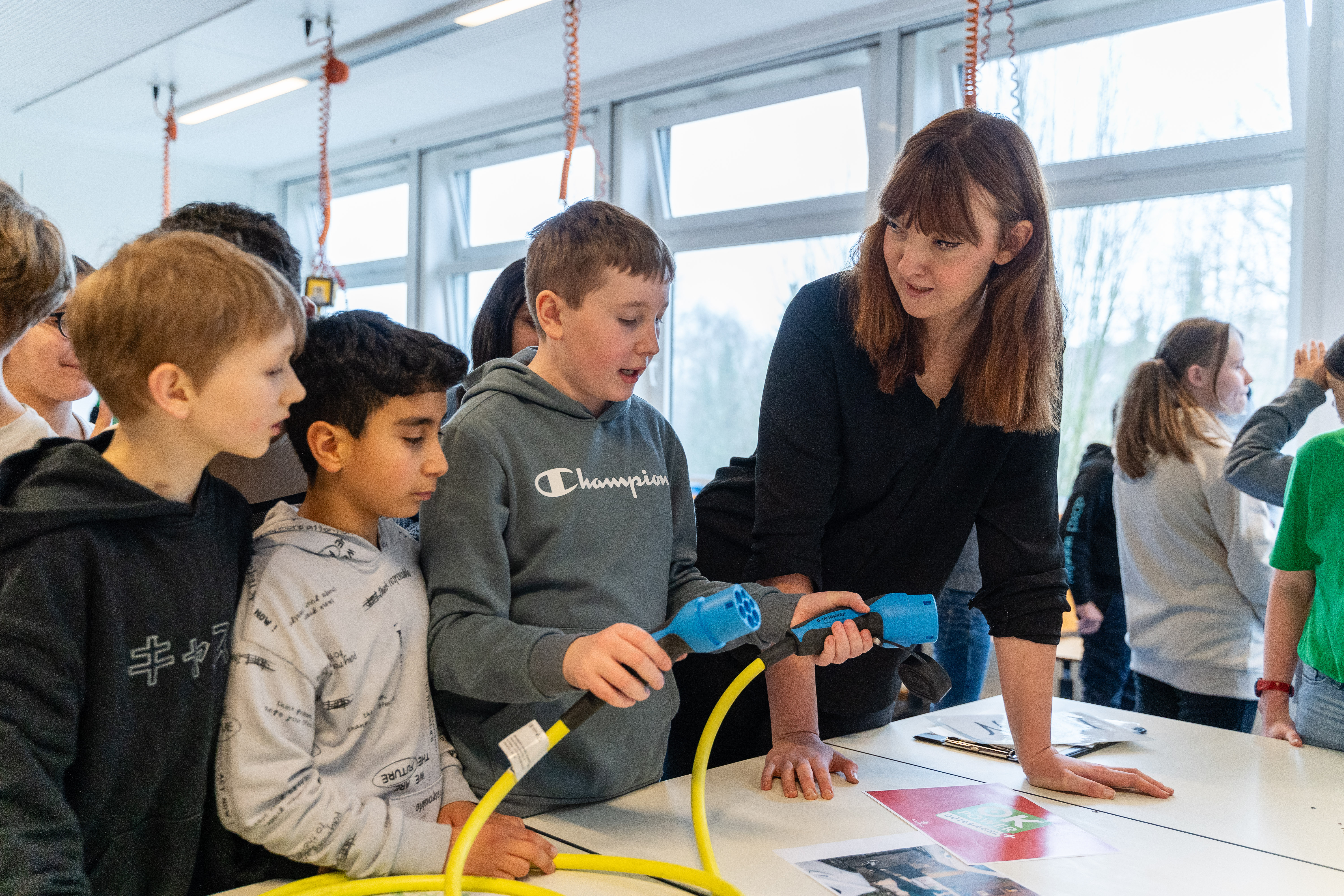 Lisa Persiel (Lünestrom) beantwortet drei Schülern Fragen zu E-Ladekabeln und -Ladesäulen.